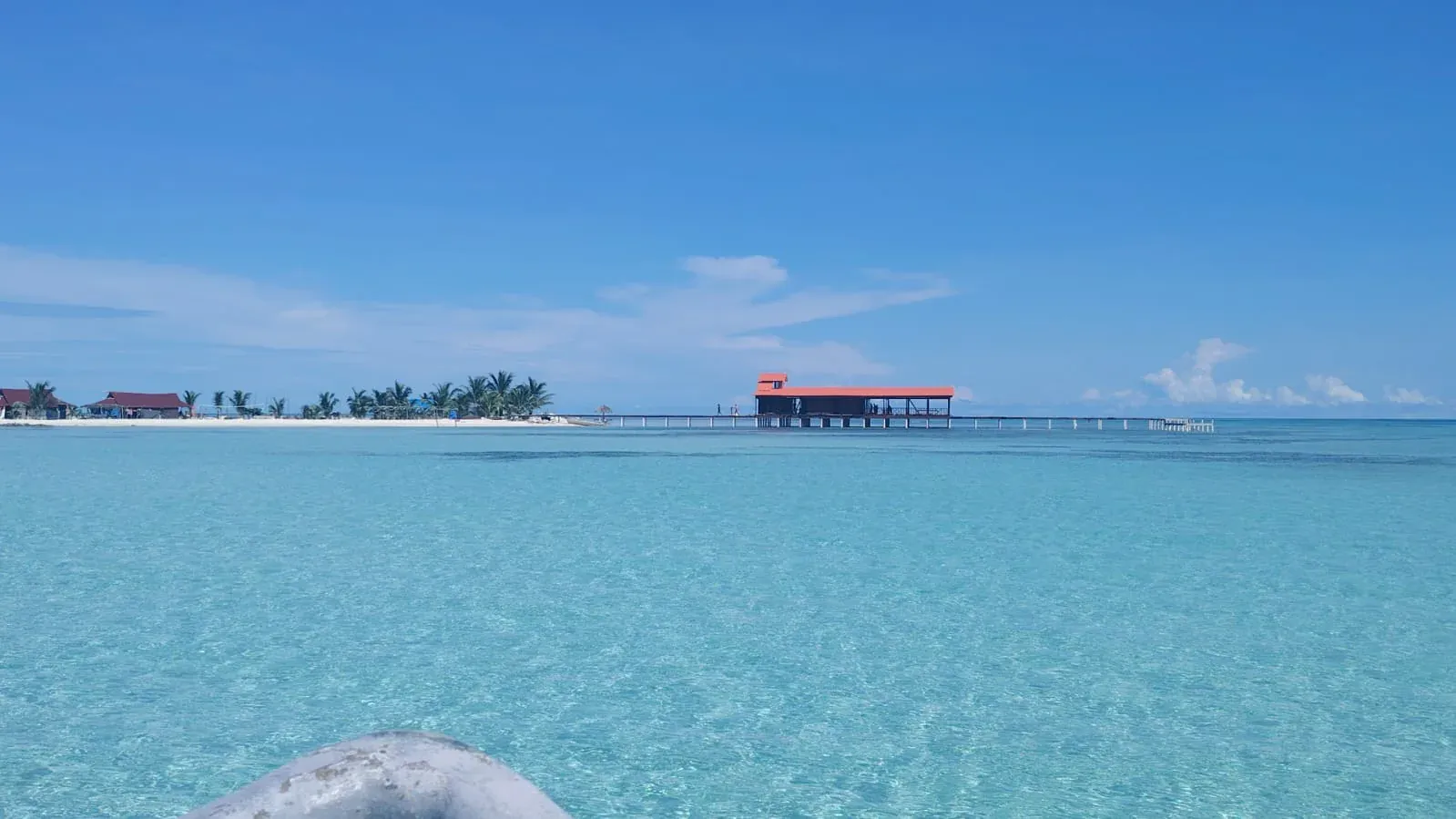 Muelle sobre el mar en calma bajo cielo azul