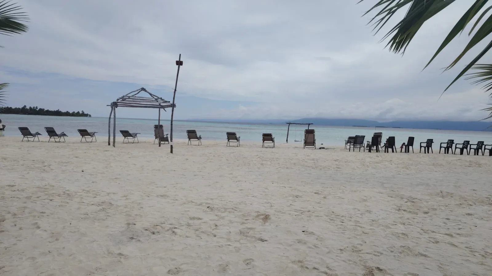 Playa de arena blanca con sillas frente al mar